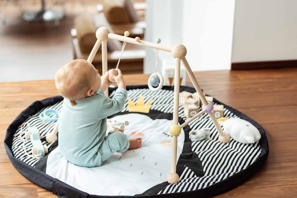 Play&Go storage bag and soft padded baby play mat, wooden toys, playing baby