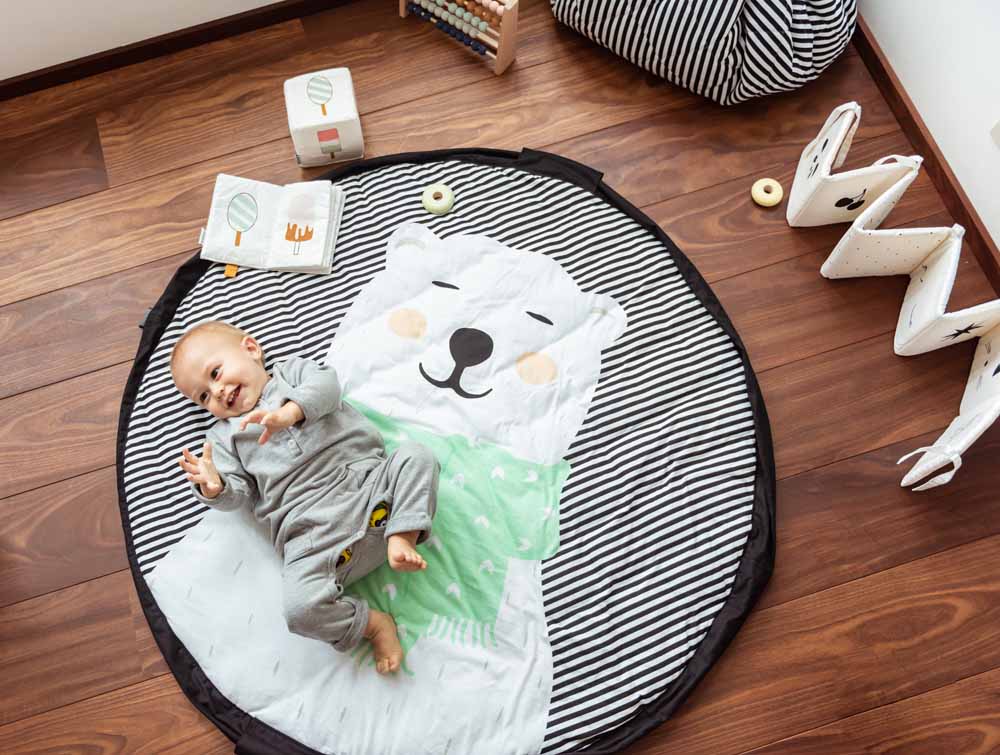 detail picture Play&Go storage bag and soft padded play mat, soft baby books, baby lying on mat