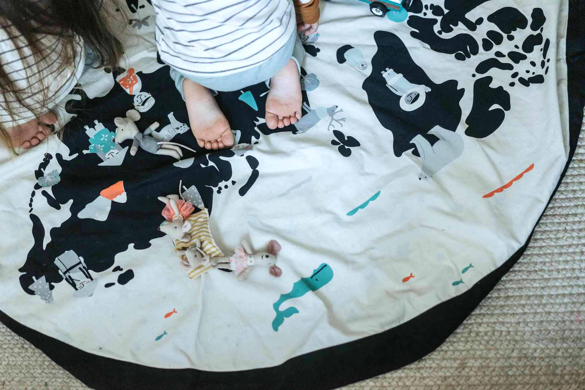 worldmap/stars toy storage bag, little cuddles, baby sitting on mat