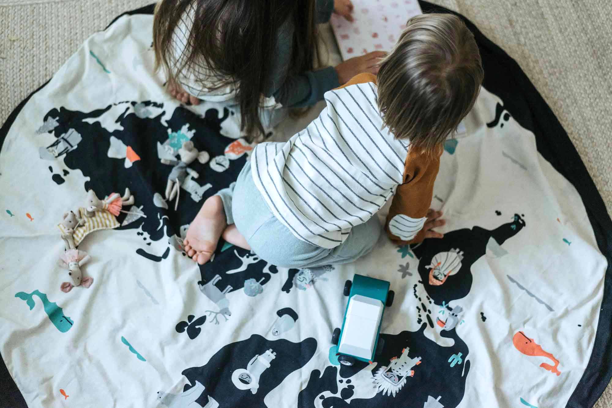 worldmap/stars toy storage bag and play mat, baby on mat and girl reading a book