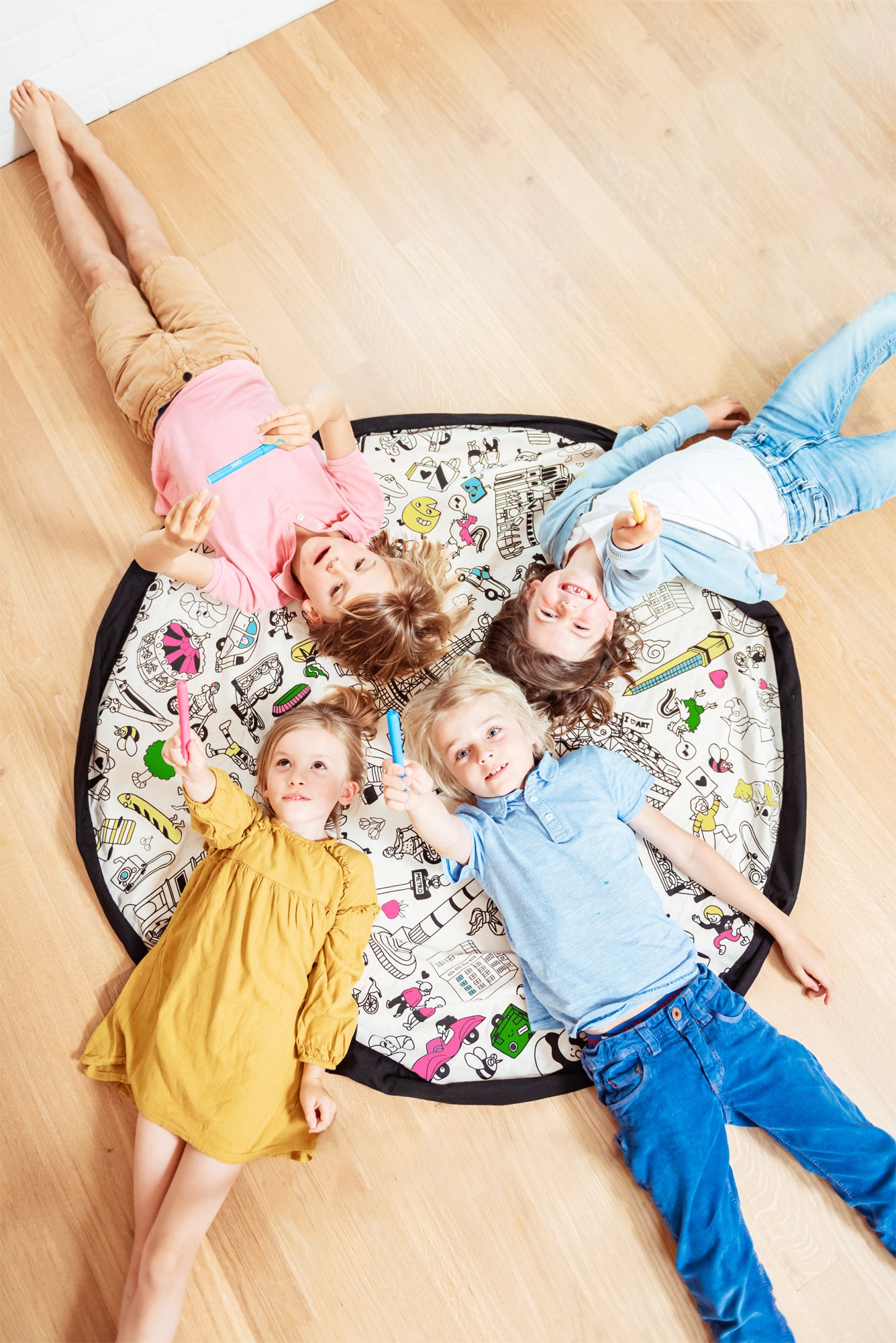 Play&Go storage bag and play mat, lots of fresh colors, 4 children lying on the mat