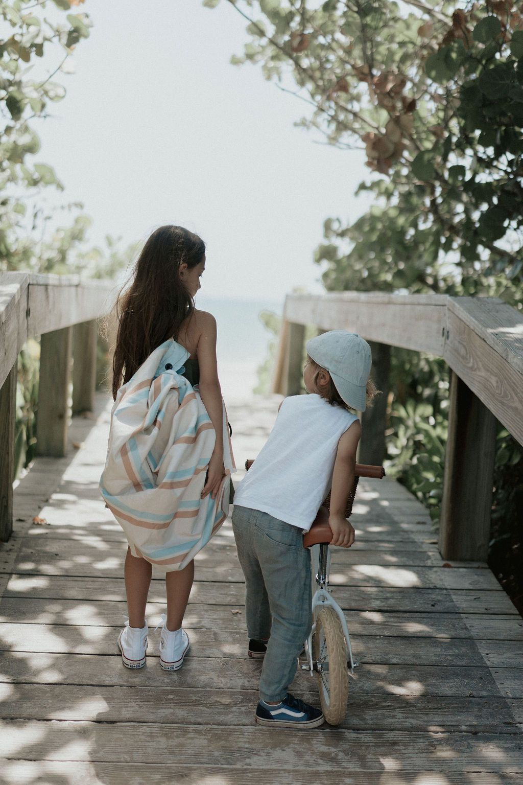 Play&Go outdoor storage bag and play mat, stripes, girl carrying bag, bicycle, little boy with cap, both on bridge