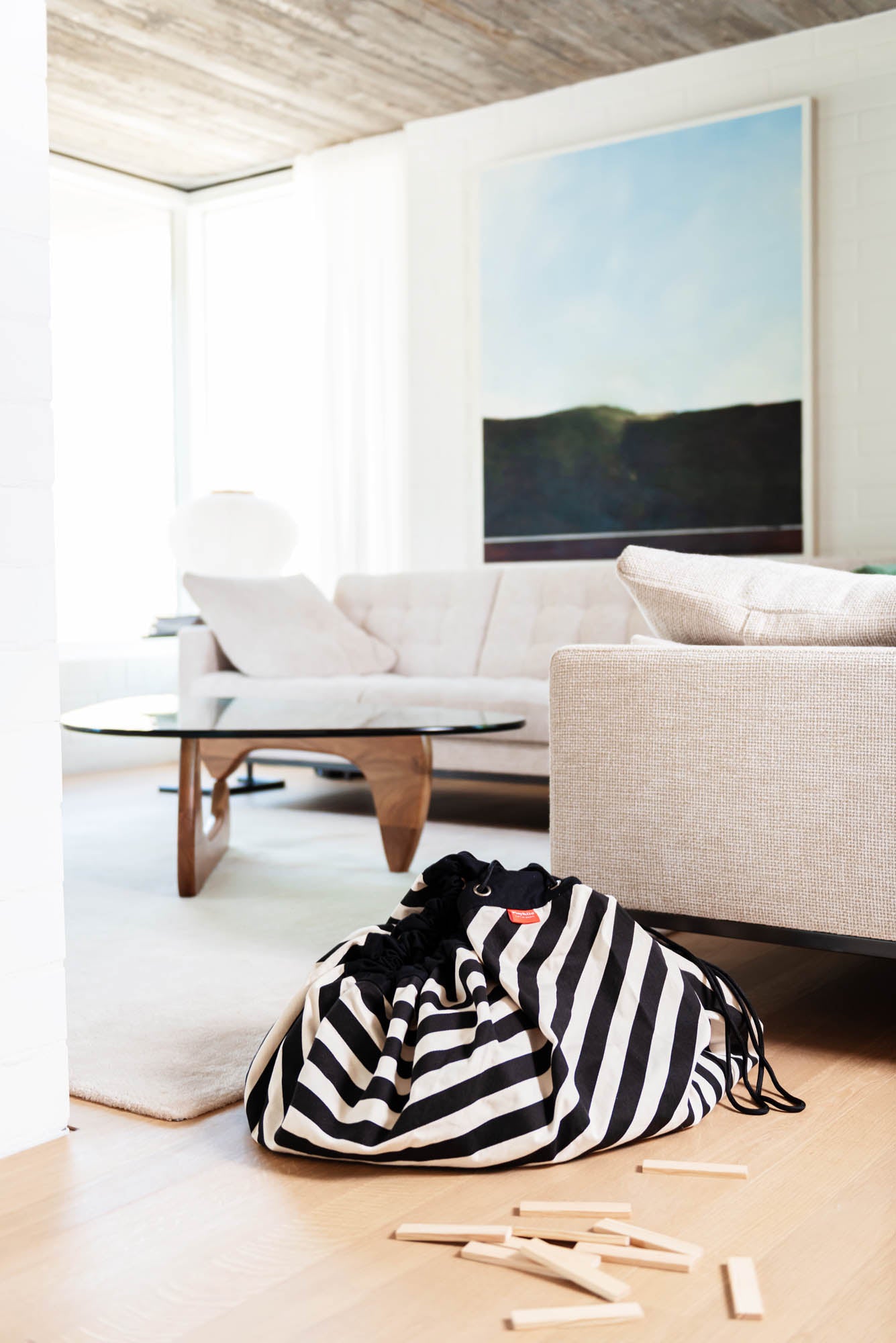 toy storage bag and play mat, bag, black and white stripes, bag in livingroom on floor next to sofa